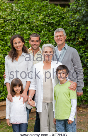 Portrait d'une famille heureuse regardant la caméra dans le jardin