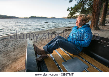 Femme assise en regardant le coucher du soleil, camion rénové Lac Payette, McCall, New York, USA