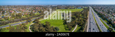 Antenna paesaggio panoramico di vetture guida su autostrada passando attraverso il tipico paesaggio suburbana a Melbourne, Australia Foto Stock