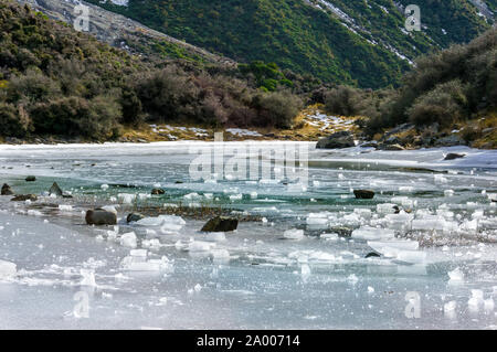 Pezzi di ghiaccio del lago ghiacciato contro la montagna invernale dello sfondo. Laghi blu, South Island, in Nuova Zelanda. Incredibili paesaggi ghiacciati paesaggio Foto Stock