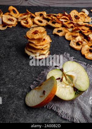 Applewith freschi pezzi di secco nel disidratatore fette di giallo e le mele rosse, snack sano concetto Foto Stock