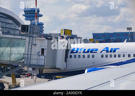 Otopeni, Romania - 11 Settembre 2019: Blu aereo collegato ad un passeggero ponte di imbarco presso l'Aeroporto Internazionale Henri Coanda, vicino a Bucarest, Foto Stock