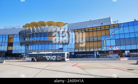 Schwechat, Austria - 15 Settembre 2019: l'Aeroporto Internazionale di Vienna (Flughafen Wien), i passeggeri di un autobus di fronte ad esso e un Austrian Airlines piano Foto Stock