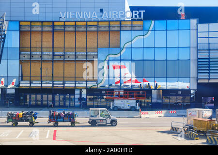 Schwechat, Austria - 15 Settembre 2019: l'Aeroporto Internazionale di Vienna / Flughafen Wien (VIE) - edificio principale con finestre di vetro, un'Austrian Airlines Foto Stock