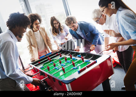 La gente di affari di grande tempo insieme.i colleghi tavolo da gioco calcio in ufficio. Foto Stock