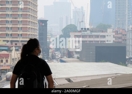 Kuala Lumpur, Malesia. Xviii Sep, 2019. Una donna che indossa una maschera chirurgica a causa di foschia a Kuala Lumpur.Più di un migliaio di scuole in Malesia sarà vicino a causa del peggioramento di fumo e il malese Meteorologia Dipartimento si aspetta la nebulosità per continuare. Secondo l Asean meteorologici specializzati (ASMC) La nebulosità è probabile che hanno originato da Indonesia e molti altri paesi sono state vittime all'aria malsana dell'inquinamento. Credito: SOPA Immagini limitata/Alamy Live News Foto Stock