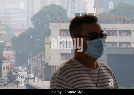 Kuala Lumpur, Malesia. Xviii Sep, 2019. Un uomo che indossa una maschera chirurgica a causa di foschia a Kuala Lumpur.Più di un migliaio di scuole in Malesia sarà vicino a causa del peggioramento di fumo e il malese Meteorologia Dipartimento si aspetta la nebulosità per continuare. Secondo l Asean meteorologici specializzati (ASMC) La nebulosità è probabile che hanno originato da Indonesia e molti altri paesi sono state vittime all'aria malsana dell'inquinamento. Credito: SOPA Immagini limitata/Alamy Live News Foto Stock