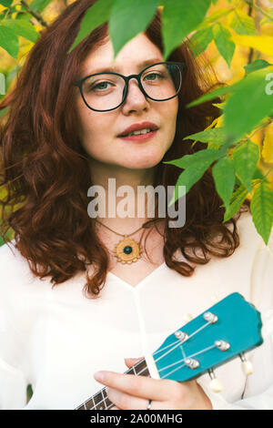 Bella giovane donna con il rosso dei capelli ricci e le lentiggini sul suo viso. Foto Stock