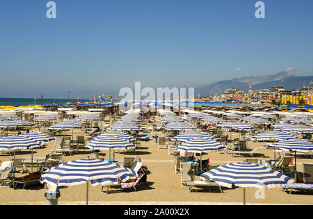 Angolo di alta vista della spiaggia sabbiosa di Lido di Camaiore con file di ombrelloni in una soleggiata giornata estiva, Toscana, la Versilia, Italia Foto Stock