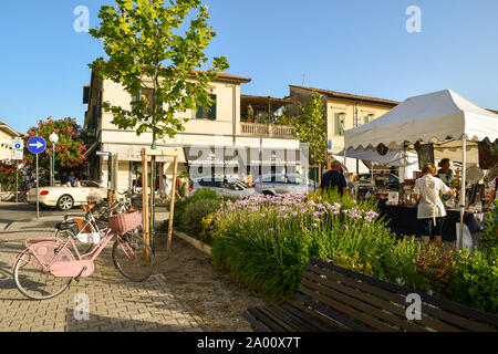 Vista sulla strada del mare città di Forte dei Marmi con uno stand del Mercato di antiquariato e una fioritura bedflower in estate, Lucca, Toscana, la Versilia, Italia Foto Stock