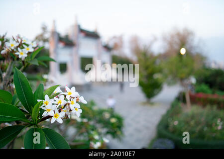 Kaohsiung, Taiwan: cancello di ingresso al Santuario dei Martiri di Kaohsiung a Shou Shan (Monkey mountain) con fiori di colore bianco nella parte anteriore Foto Stock