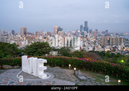 Kaohsiung, Taiwan: la parola amore in lettere gigante con luci incandescenti nella parte anteriore della Skyline di Kaohsiung dopo il tramonto al Santuario dei Martiri Foto Stock