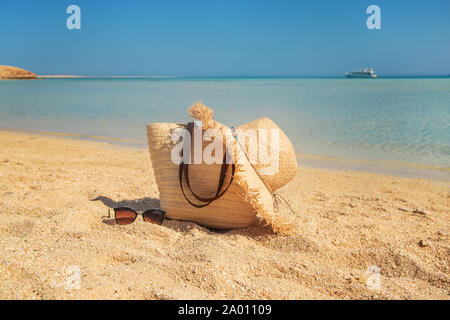 Borsa e hat sulla spiaggia vicino al mare. Messa a fuoco selettiva. la natura. Foto Stock