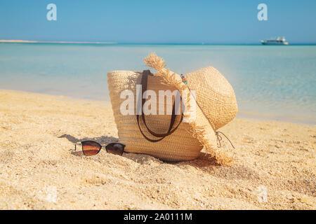 Borsa e hat sulla spiaggia vicino al mare. Messa a fuoco selettiva. la natura. Foto Stock