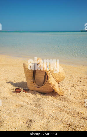 Borsa e hat sulla spiaggia vicino al mare. Messa a fuoco selettiva. la natura. Foto Stock