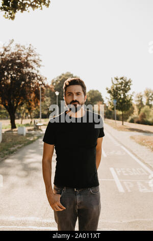 Ritratto di un giovane barbuto che si trova all'aperto nella natura Foto Stock