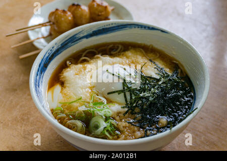 In tradizionale stile giapponese ramen, soba noodle soup con polpette di riso su un bastone e il tè verde sullo sfondo Foto Stock