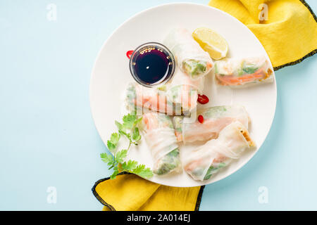 Vegetariano involtini primavera con tofu marinato, carote e daikon e coriandolo su sfondo blu. Vista superiore Foto Stock