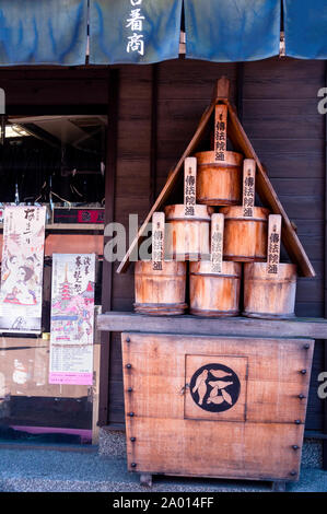 Secchi di legno giapponesi esposti sotto le tende Noren a Tokyo, Giappone. Foto Stock