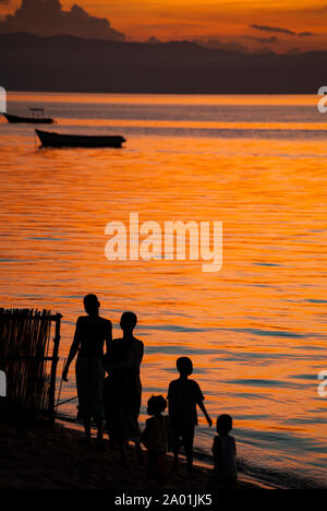 Sera silhouette di una famiglia raccolta sulla riva del lago Malawi. Foto Stock