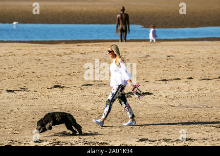 Dog walker a Crosby, Merseyside. Regno Unito Meteo. 19 Settembre, 2019. Regno Unito Meteo; luminoso per iniziare la giornata in Crosby come le persone godono di esercitare sui marittimi via lungomare. Credito: MWI/AlamyLiveNews Foto Stock