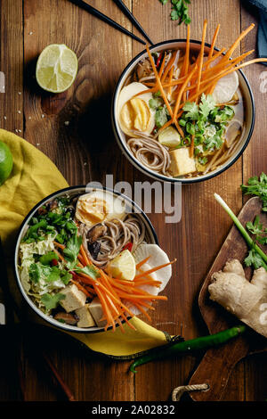 Vegetariano miso ramen con funghi shiitake, tofu fritto, carota, cavolfiore, porri e calce. Cucina asiatica Foto Stock
