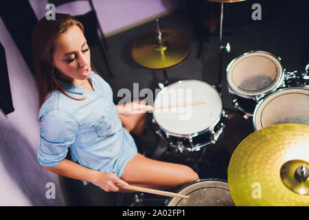 Fotografia di una femmina batterista suonare un drum set sul palco. Foto Stock