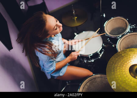 Fotografia di una femmina batterista suonare un drum set sul palco. Foto Stock