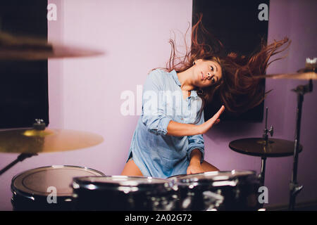 Fotografia di una femmina batterista suonare un drum set sul palco. Foto Stock