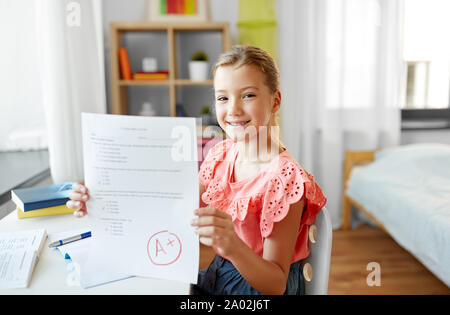 Ragazza dello studente con la scuola test buon segno a casa Foto Stock