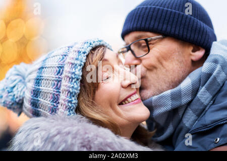 Close up di felice coppia senior baciare in inverno Foto Stock