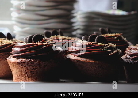 Dark Chocolate muffin guarnita con glassa di cioccolato, close up, piastre aspirato in background Foto Stock