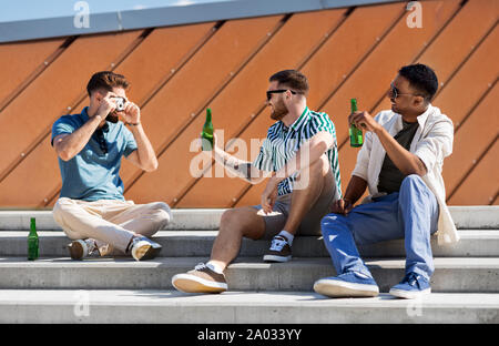 Uomo di fotografare gli amici a bere una birra su strada Foto Stock
