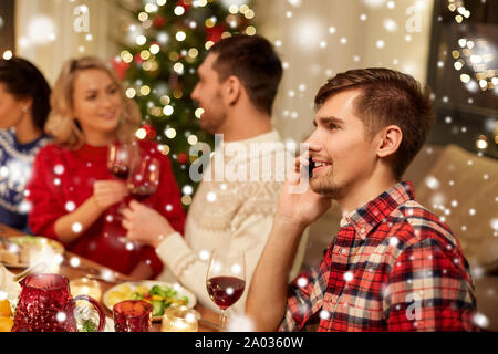 L'uomo chiamando sullo smartphone a cena di natale Foto Stock