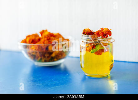 Elaborazione di fiori secchi Le calendule. Bottiglia di Chornobrivtsi olio essenziale. Tages di estratto di fiori, tintura, infusione. Foto Stock