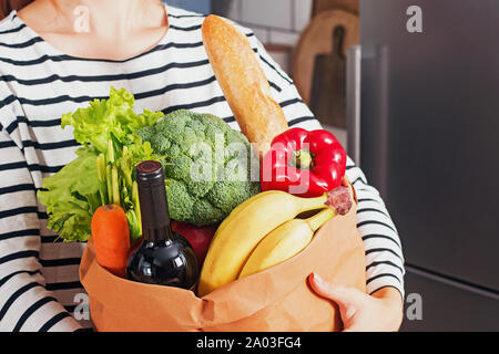 Donna di mani sacchetto di carta con diversi vegetali e gli altri prodotti acquistati nel negozio di generi alimentari di close-up Foto Stock