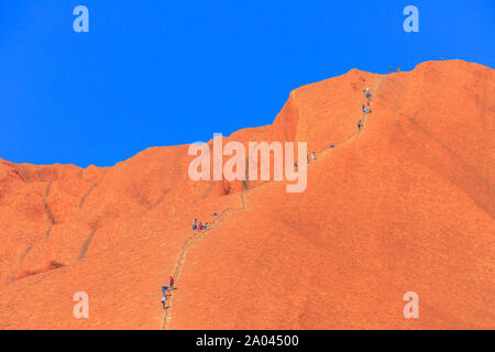 Uluru, Territorio del Nord, l'Australia - Agosto 23, 2019: persone salire su Ayers Rock. Climbing Uluru è sacro al popolo Anangu, i proprietari tradizionali di Foto Stock