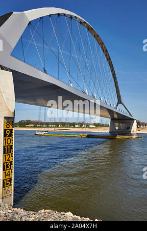 River Barge navigazione sotto il Oversteek ponte che attraversa il fiume Waal a Nijmegen nei Paesi Bassi Foto Stock