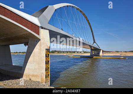 River Barge navigazione sotto il Oversteek ponte che attraversa il fiume Waal a Nijmegen nei Paesi Bassi Foto Stock