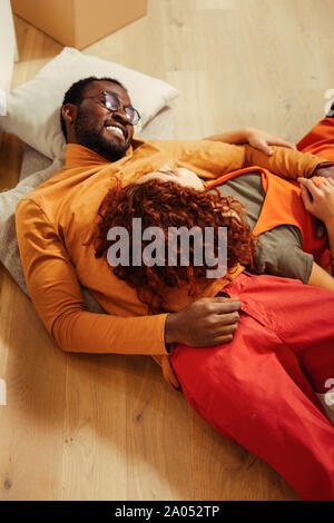 Colori luminosi. Rilassato uomo barbuto giacente su plaid e accarezza il suo partner Foto Stock