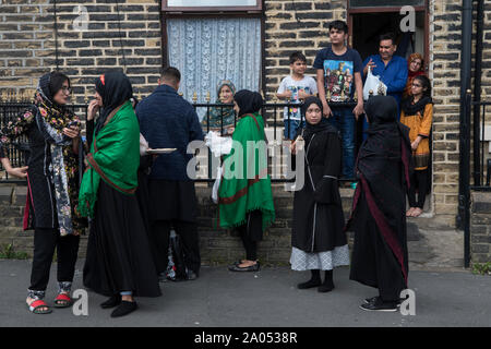 Comunità musulmana Bradford 2019, 2010s Regno Unito. Le famiglie al di fuori della loro casa, nel giorno della parata di Ashura, i musulmani sciiti ricordano il martirio di Hussain, ucciso nel deserto di Karbala nell'attuale Iraq nel 680 d.C. HOMER SYKES Foto Stock