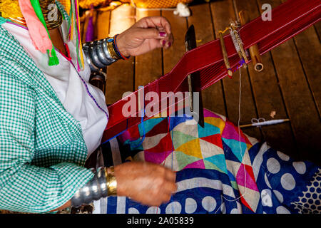 Un senior della Donna dal Kayan (lungo collo) gruppo etnico tessuto di tessitura, Lago Inle, Stato Shan, Myanmar. Foto Stock
