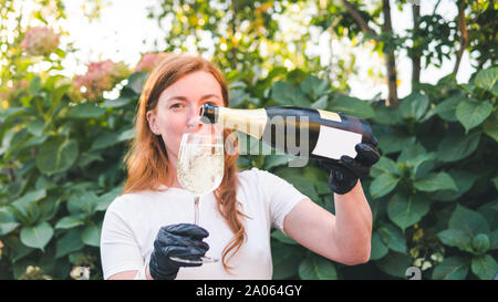 Barista versando champagne in vetro, close-up all'esterno. Concetto di bere alcol e ristorante, servizio catering Foto Stock