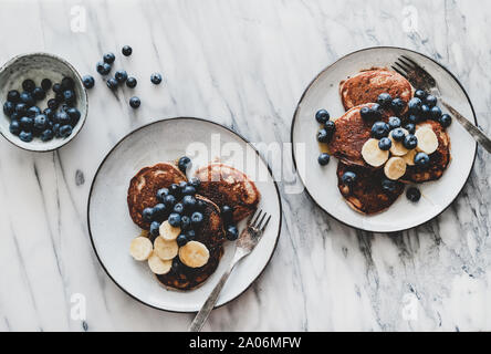La prima colazione con banana pancake con bluelerry e miele in piastre Foto Stock