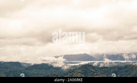 Drone panoramica vista sulle montagne coperte di neve durante l'autunno, veduta aerea alpi svizzere con il lago in coperto nebbia in Kanchanaburi Thailandia Foto Stock