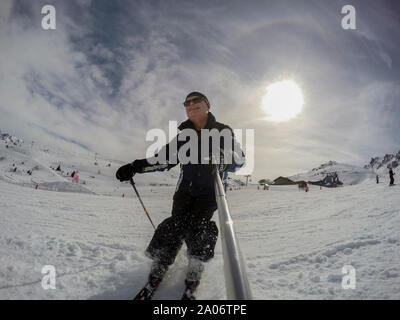 Di mezza età sciatore maschio tenendo selfie mentre lo sci Foto Stock
