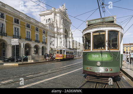 Lisbona, Portogallo - agosto, 2019: old vintage tram turistico passando dalla tipica strada di ciottoli di fronte a Rua Augusta arco di trionfo in estate Foto Stock