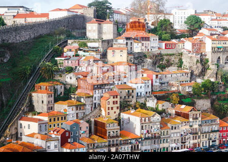 Porto, Portogallo - Dicembre 2018: Vista di tradizionali case di Porto, con funicolare Guindais e Fernandina parete sulla sinistra. Foto Stock