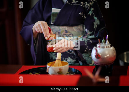 Una donna che indossa un kimono durante una tradizionale cerimonia del tè giapponese Foto Stock