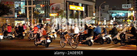 I giovani utilizzano i propulsori a benzina scooter come veicolo principale della città di Kaohsiung, Taiwan, di giorno e di notte. Foto Stock